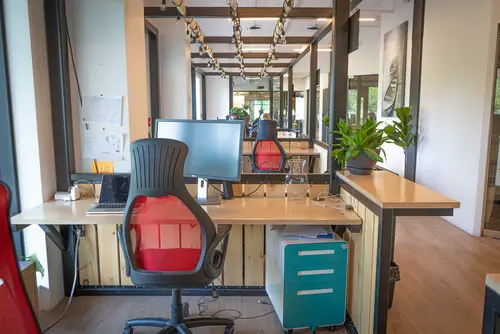 Dedicated desk workspace - private fixed desk for one person in open coworking space