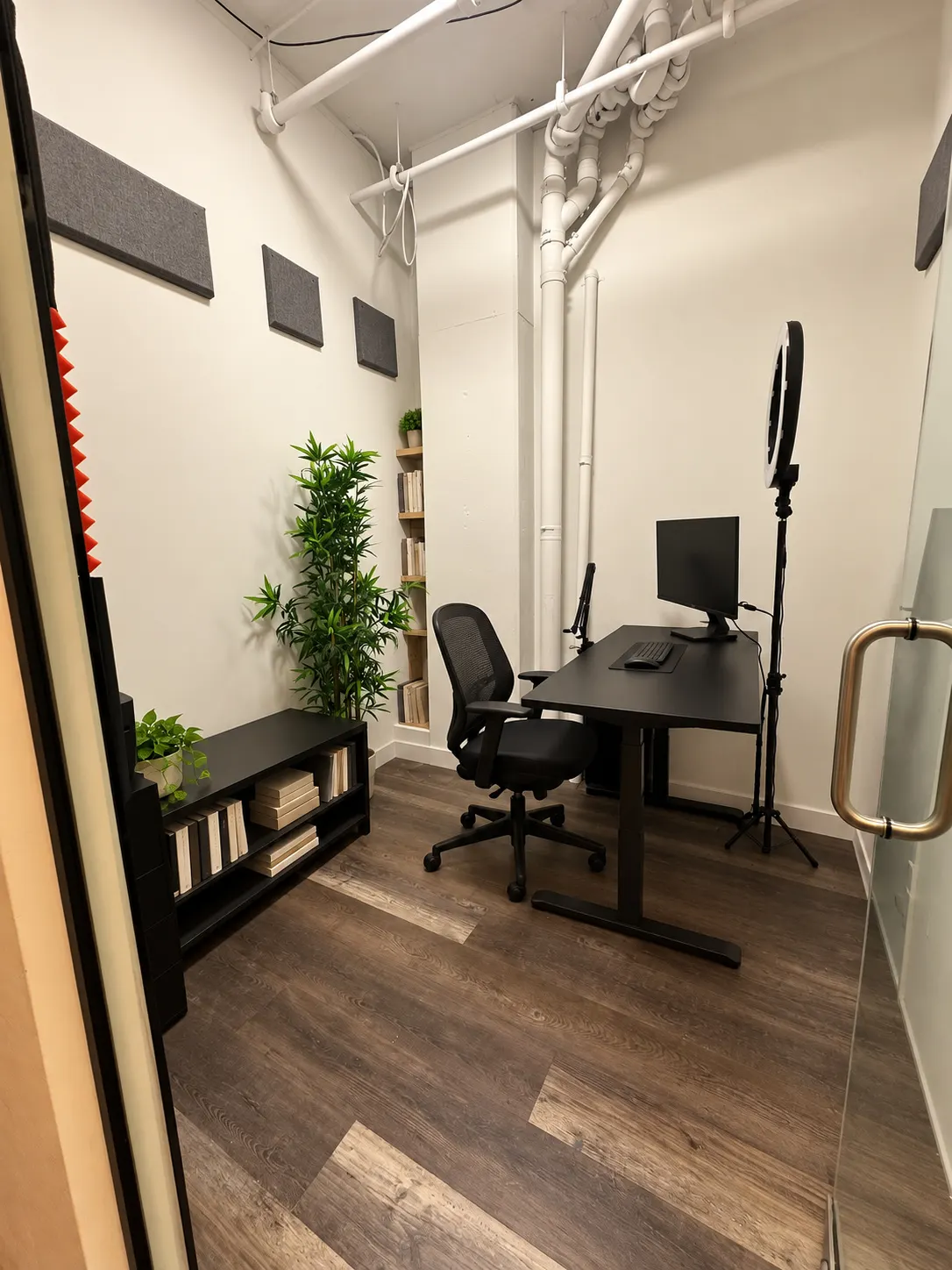 Private office 104-1 at 2727 Coworking, Griffintown: the narrow office seen through its open glass door, with desk, plants and bookcase